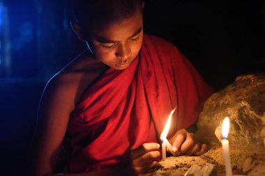 Bagan, Myanmar - Desember 8: eski pagoda tapınakta mandalay Tarih Parkı içinde mumlar ile dua genç Budist rahip. Desember 8, 2016, Myanmar
