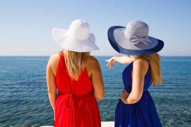 Kırmızı ve mavi elbiseler Kıbrıs'ta plajda sarışın kadın.