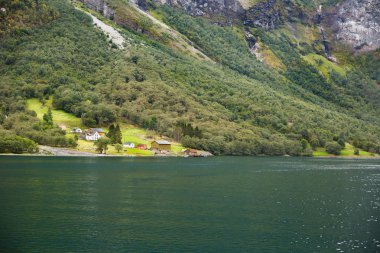 Naeroyfjord, dağlar ve Norveç'te geleneksel köy evi ile manzara.