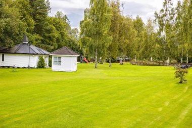 Beyaz ahşap evler ile manzara ve Norveç'te Bahçe.