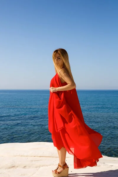 キプロスのビーチで赤いドレスを着てかなりブロンドの女性 — ストック写真