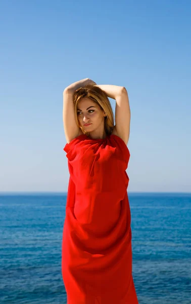 在塞浦路斯海滩的红色礼服漂亮的金发女郎 — 图库照片