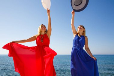 Kırmızı ve mavi elbiseler Kıbrıs'ta plajda sarışın kadın.