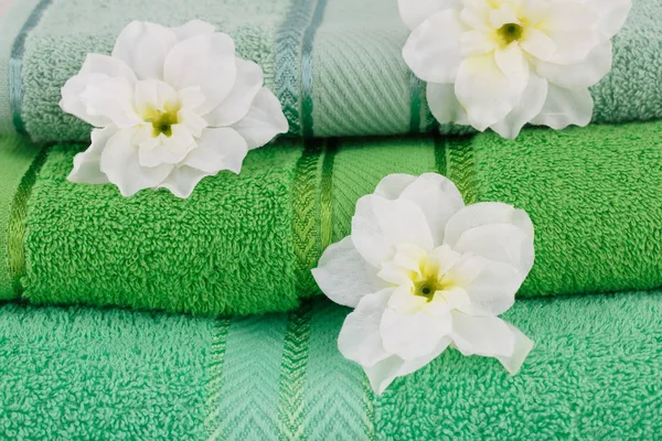 Folded towels and flowers closeup picture.