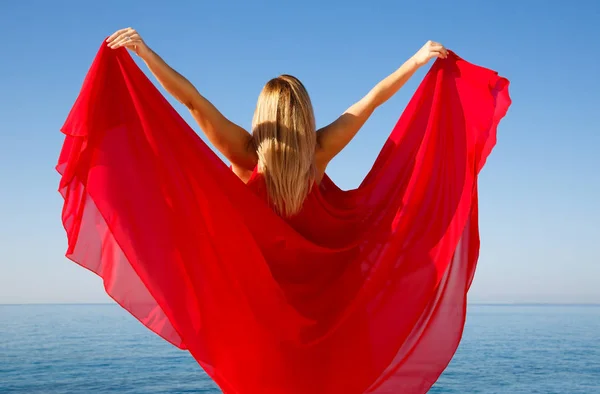 在塞浦路斯海滩的红色礼服的金发女郎 — 图库照片