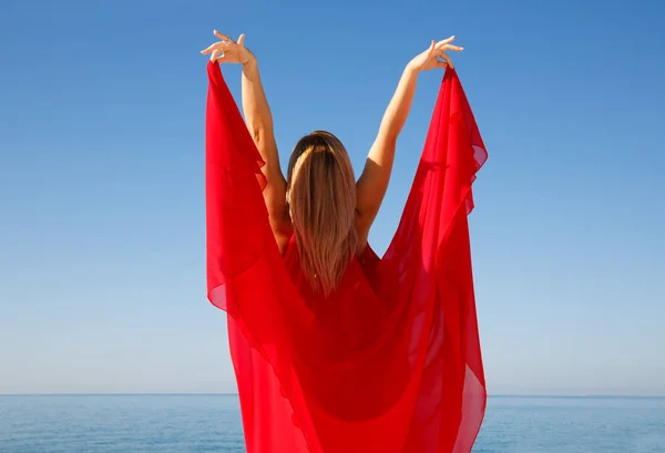 キプロスのビーチでの赤いドレスで金髪の女性 — ストック写真