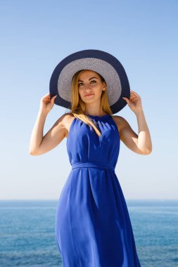 Kıbrıs'ta plajda mavi elbiseli sarışın kadın.