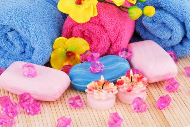 Spa havlu, mumlar, sabunlar ve çiçekler ile bambu arka plan ayarla.
