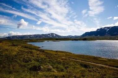 Dağ, göl, gökyüzü ve bulutlar Norveç'te manzara.