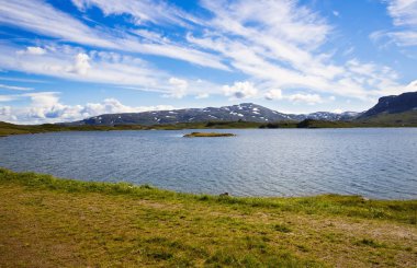 Dağ, göl, gökyüzü ve bulutlar Norveç'te manzara.