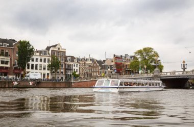 Amsterdam, Hollanda-18 Ağustos, 2015-Kanal tekneleri, binalar ve ağaçlar, denizden manzaralı.