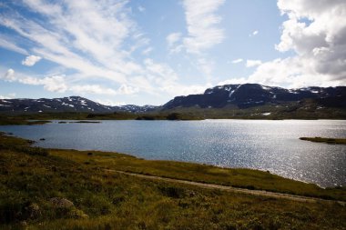 Dağ, göl, gökyüzü ve bulutlar Norveç'te manzara.