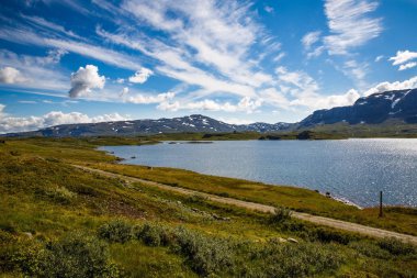 Dağ, göl, gökyüzü ve bulutlar Norveç'te manzara.