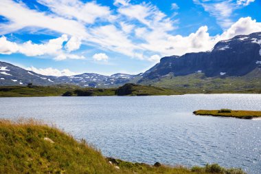 Dağ, göl, gökyüzü ve bulutlar Norveç'te manzara.