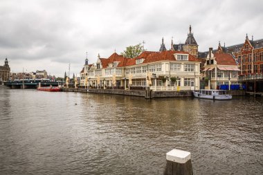 Amsterdam, Hollanda-18 Ağustos, 2015-Kanal tekneleri ve bina, su manzaralı.