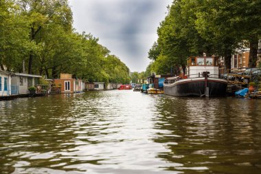 Amsterdam, Hollanda-18 Ağustos, 2015-Kanal tekneleri ve ağaçlar,, su manzaralı.