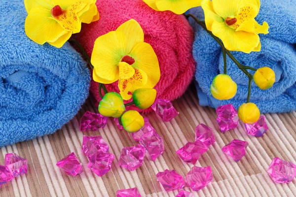 Colorful Rolled Towels Yellow Orchid Flowers Pink Stones Cloth Background — Stock Photo, Image