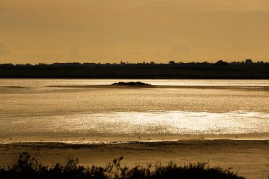 Gün batımında, Kıbrıs Larnaka Tuz Gölü nün parlayan yüzeyi.