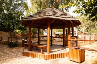 Wooden round pavillion with bench in the park. clipart