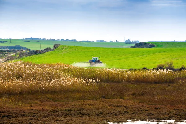 キプロスの沼近く大規模なグリーン フィールド上の化学物質の散布トラクター — ストック写真