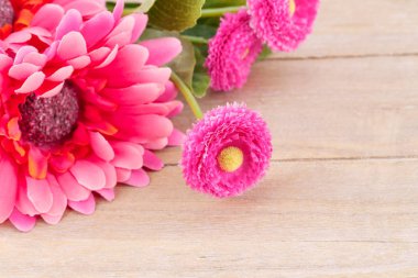 Ahşap zemin, portre resim üzerine pembe yapay çiçekler.