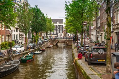 Amsterdam, Hollanda-18 Ağustos, 2015-Kanal tekneleri, köprü ve binalar, denizden manzaralı