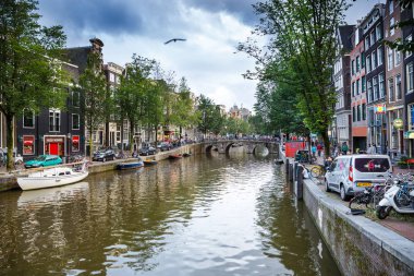Amsterdam, Hollanda-18 Ağustos, 2015-Bridge ile bisiklet, tekne, araba ve Hollanda başkentinde binalar ile kanal.
