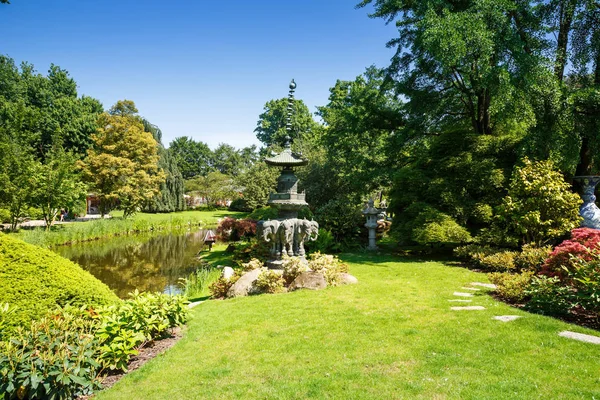 Manzara wth Gölü, heykel ve ağaçlarda Hagenbeck Bahçesi, Hamburg, Almanya.