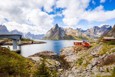 Yüksek rocky Dağları, geleneksel evler, köprü ve Hamnoya, Norveç fiyordu manzara.