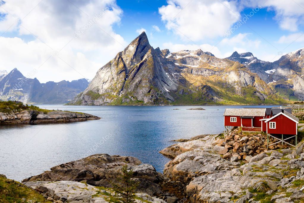 Landscape with high rocky mountains, traditional houses and fjord in Hamnoya, Norway.