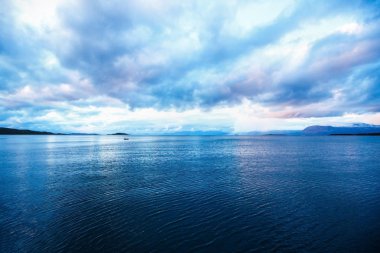 Harstad, Norveç kutup günün gece yarısı bulutlar ile deniz manzara.