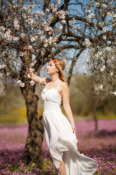 ブルーミング ガーデンの白いドレスの若い美しいロマンチックなブロンドの女性 — ストック写真