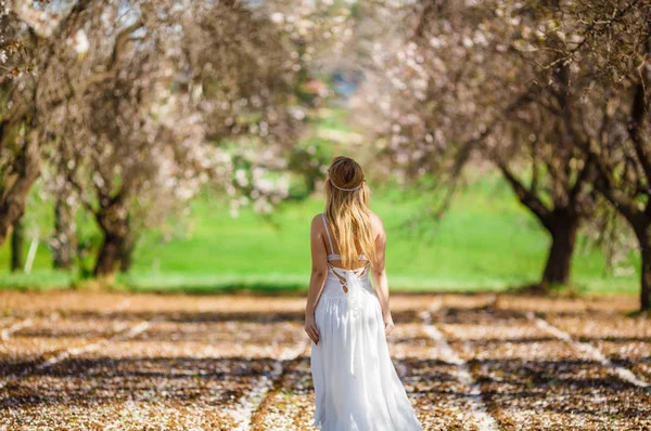 ブルーミング ガーデンの白いドレスの若い美しいロマンチックなブロンドの女性 ロイヤリティフリーのストック写真