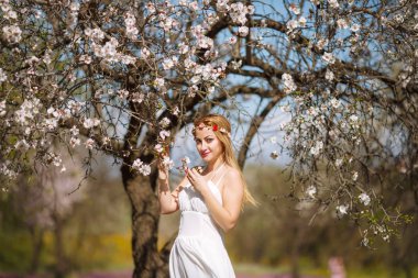 Çiçek bahçe beyaz elbiseli Genç güzel romantik sarışın kadın.