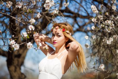 Çiçek bahçe beyaz elbiseli Genç güzel romantik sarışın kadın.