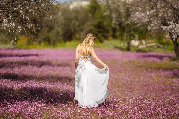 ブルーミング ガーデンの白いドレスの若い美しいロマンチックなブロンドの女性 — ストック写真