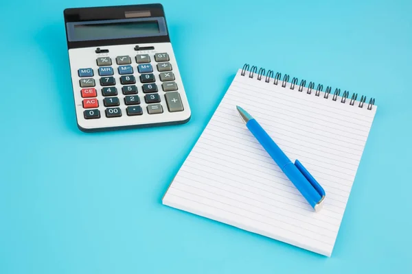 Calculator, blue pen and notepad — Stock Photo, Image