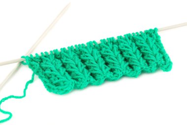 Beyaz arkaplanda örgü iğneleri olan yeşil iplik..