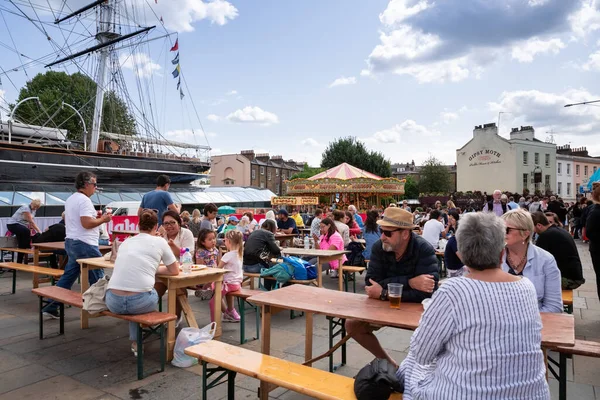 Londra, İngiltere - 20 Ağustos 2019 - Cutty Sark gemisinde dinlenen, bira içen ve Çingene Güve barının yakınındaki açık kafede öğle yemeği yiyen insanlar.