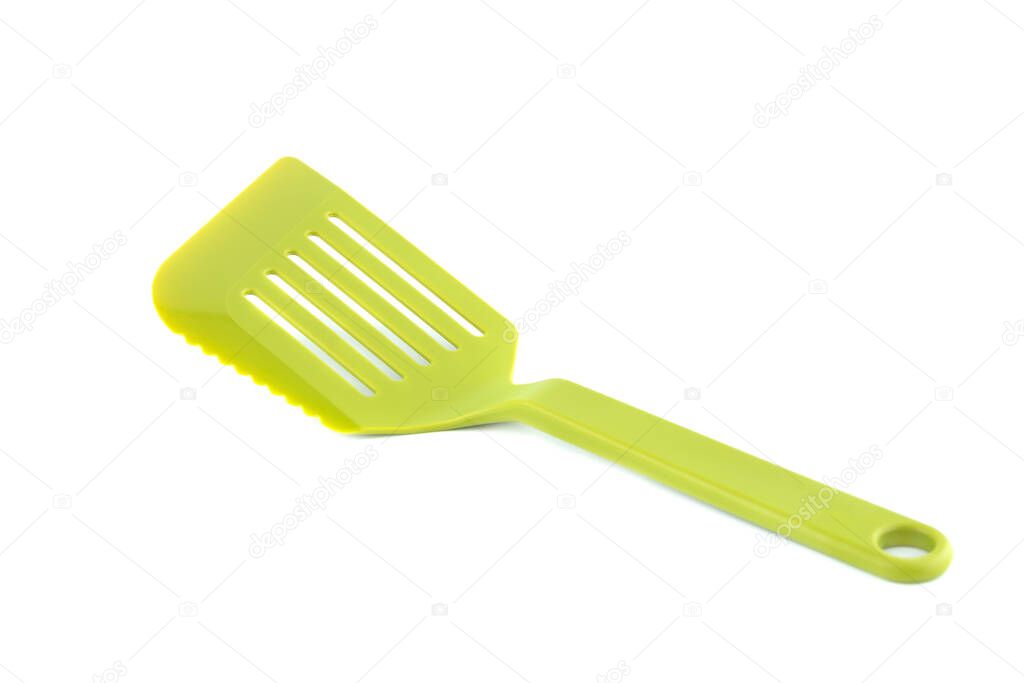 Green plastic kitchen utensil spaluta isolated on white background.