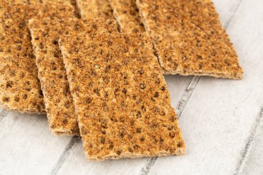 Gri ahşap arka planda baharatlı kraker yığını.