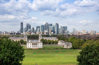 Londra, İngiltere - 20 Ağustos 2019 - Canary Wharf finans bölgesi kurumsal ofis modern binaları, Greenwich manzaralı. Kraliçe 'nin Evi ve Eski Kraliyet Donanma Koleji (şimdi Denizcilik Müzesi).