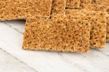 Gri ahşap arka planda baharatlı kraker yığını.