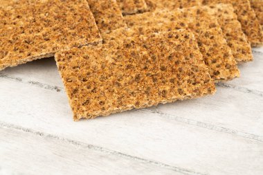 Gri ahşap arka planda baharatlı kraker yığını.