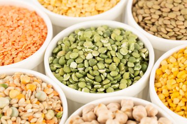 Beyaz seramik kaselerdeki farklı Groats koleksiyonu. Bezelye, renkli mercimek, nohut, buğday taneleri..