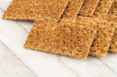 Gri ahşap arka planda baharatlı kraker yığını.