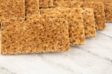 Gri ahşap arka planda baharatlı kraker yığını.