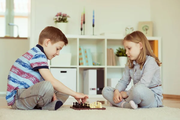 つの小さな子供たちが感情的に自宅にチェス — ストック写真