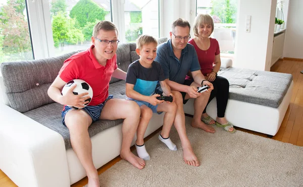 祖父母 他们的儿子和孙子在家里玩电脑游戏在沙发上 — 图库照片