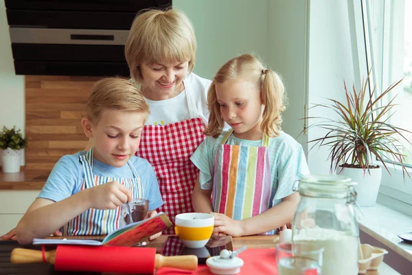快乐的祖母与她的孙子在烘烤松饼和曲奇饼期间乐趣 — 图库照片